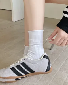 Primo piano di calze a costine in cotone bianco con risvolto stile college coreano.