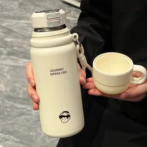 Detailed view of cream stainless steel thermos bottle with dual drink lid and cute print.