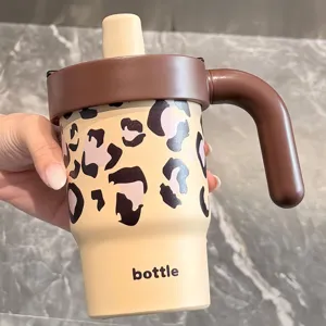 Stainless steel insulated cup detail with cute leopard print handle and straw lid design.