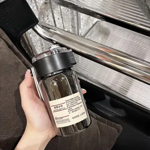 Primo piano dettagliato della borraccia portatile trasparente con coperchio e pratico manico.