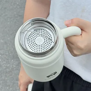 Stainless steel insulated coffee mug with handle and tea strainer for office and travel use.