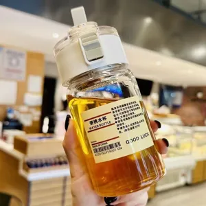 Pratica bottiglia d'acqua portatile in plastica con coperchio e manico per ufficio.