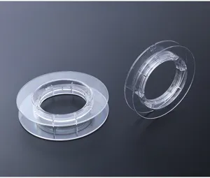 Vue détaillée de bobine de fil en plastique transparent, structure solide et bords lisses.