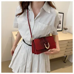 Dettaglio borsa a tracolla coccodrillo rosso, elegante borsa quadrata con serratura metallica.