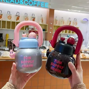Primo piano dettaglio di tazza d'acqua in plastica carina con manico portatile e ciondolo.