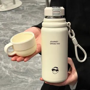 Detailed view of portable stainless steel vacuum insulated water bottle with strap and cup lid.