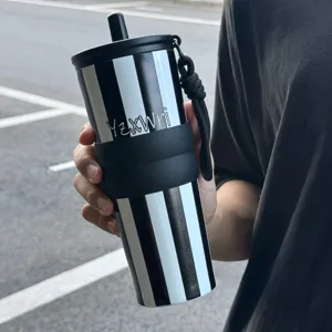 Stainless steel tumbler detail showcasing black and white stripes, silicone grip and straw lid.