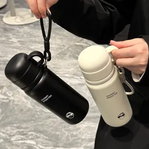 Detail shot of portable 304 stainless steel thermos flask, featuring dual-drink lid and strap.