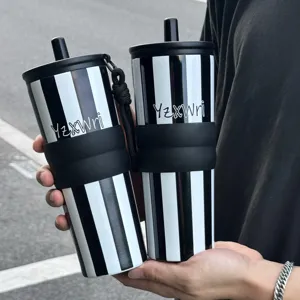 Stainless steel tumbler with straw and silicone sleeve, black and white striped detail view.