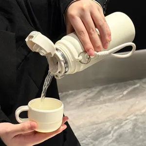 Detailed view of beige insulated water bottle pouring water into a matching cup, portable design.