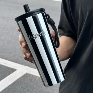 Detailed shot of black and white striped stainless steel tumbler with straw and handy strap.