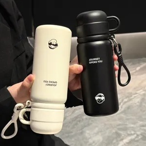 Detail view of portable stainless steel insulated water bottle with dual-drink lid and strap.