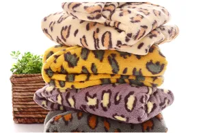 Soft coral fleece leopard print towel stack detail shot showing rich colors and plush texture.