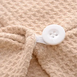 Detalle de gorro de secado de microfibra nido de abeja con boton y elastico absorbente rapido.