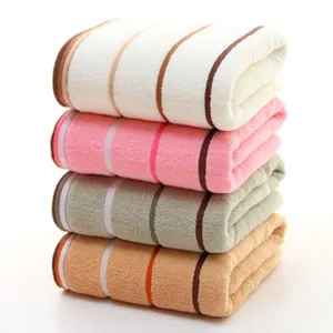 Close-up view of soft cotton striped face towel stack, absorbent bathroom detail.