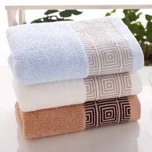 Detail shot of thick absorbent cotton face towels with stylish geometric pattern in three colors.