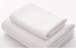 White waffle weave towel detail, soft and quick drying fabric texture closeup.
