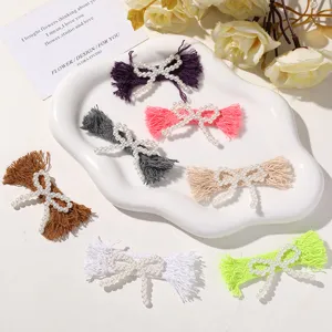 Fabric pearl bow hair clip detail showing multiple colors and exquisite fringed cloth design.