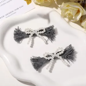 Grey fabric imitation pearl bow hair clip detail view, handmade autumn winter minimalist accessory.