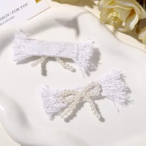 Pearl bow hair clip detailed view, white woven fabric accessory for women fashion daily wear.
