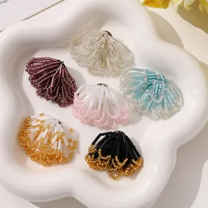 Nahaufnahme handgefertigter farbblockierter Perl Blumen für DIY Schmuck und Accessoires.