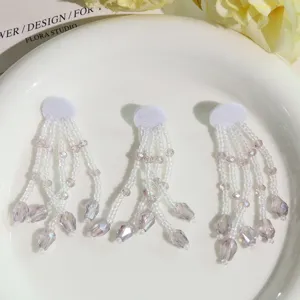 Vista detallada de borlas de cuentas de cristal translúcido hechas a mano, accesorios elegantes.