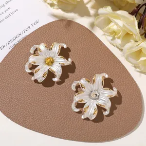 Vue détaillée de magnifiques accessoires de cheveux DIY en fleurs blanches dorées avec cristaux.