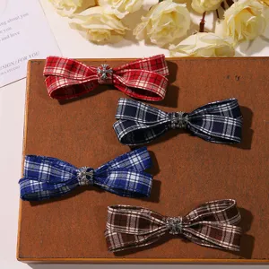 Detailed view of plaid fabric hair clips featuring classic cross metal charms, elegant side pin.