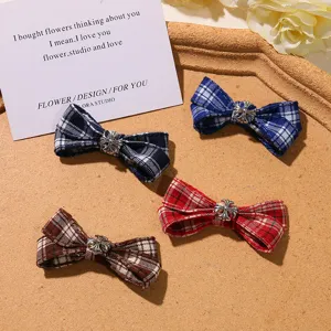Detailed view of British style plaid bow hair clips with metal cross charm, 4 assorted colors.