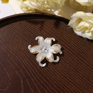 Détail de la fleur en strass dorée montrant un artisanat exquis et un centre scintillant.