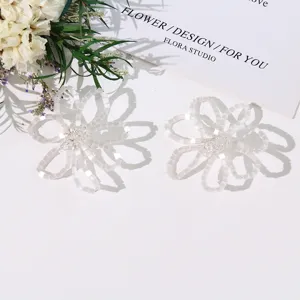 Detailed shot of white beaded flower DIY jewelry accessory, hollow design, elegant handmade charm.