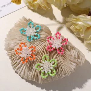 Close-up of colorful beaded hollow flower charms, dopamine style DIY accessories.