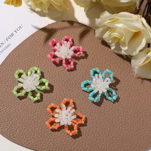 Close-up detail of colorful beaded flower DIY charms, cute tube bead accessories for crafts.