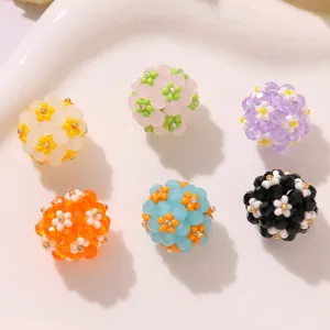 Detailed close-up of colorful daisy beaded flower balls for DIY earrings and hair accessories.