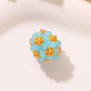 Close-up detail of blue and orange beaded flower ball charm, ideal for DIY crafting project.