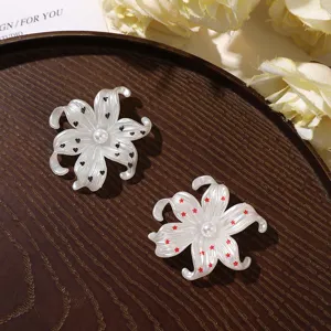 Witte bloem DIY accessoires met parelhart en hartjes sterren motieven voor telefoonhoesjes decor.