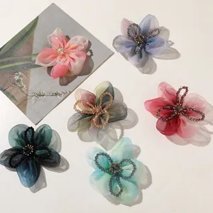 Close-up detail of gradient organza five-petal flower hair ties with crystal bead center for DIY