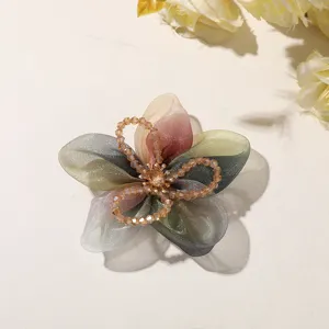 Detailed view of the ink gradient organza five petal flower with crystal beads for hair accessory.