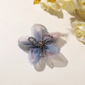 Close-up detail shot of a gradient organza five-petal flower with crystal bead center.