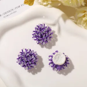 Vista detallada de dijes de flores de cuentas moradas hechos a mano, accesorios de joyería.