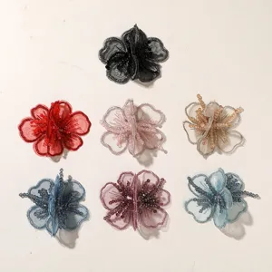 Primer plano de parches de flores de organza con cuentas, manualidades DIY y accesorio para el cabello.
