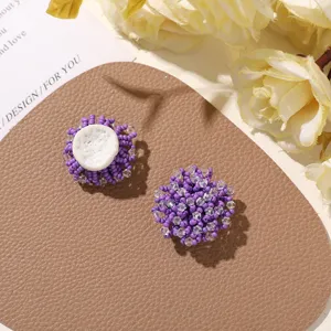 Primer plano del detalle de flor de cuentas de semillas violeta taro, artesanía delicada para aretes.