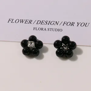 Close-up detail of vintage black pearl five-petal flower DIY alloy accessories for crafts.