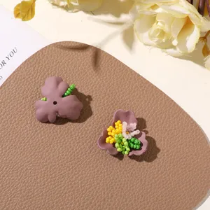 Close-up shot of handmade purple three-petal flower charms with vibrant seed beads.