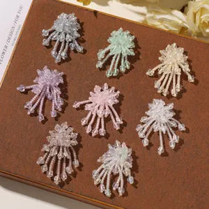 Primer plano de accesorios DIY de flores de cuentas coloridas para pendientes, zapatos y pelo.