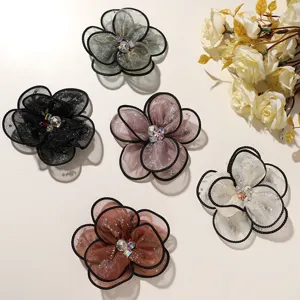 Close-up detail of multi-layer mesh floral appliques with sparkling rhinestone centers.