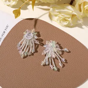 Primer plano detallado de accesorios de pendientes de flecos de cuentas de colores.