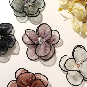 Detailed view of handmade mesh rose flower DIY accessories with sparkling rhinestones and black borders.