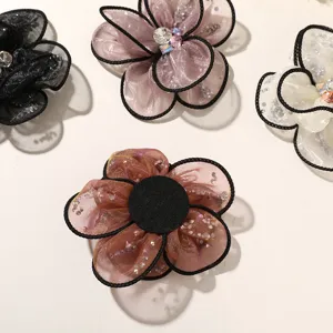 Organza flower detail shot, rhinestone embellishments, DIY hair accessory material.