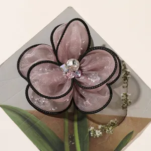 Exquisite mesh fabric flower detail, featuring black trim and sparkling crystal rhinestone center.